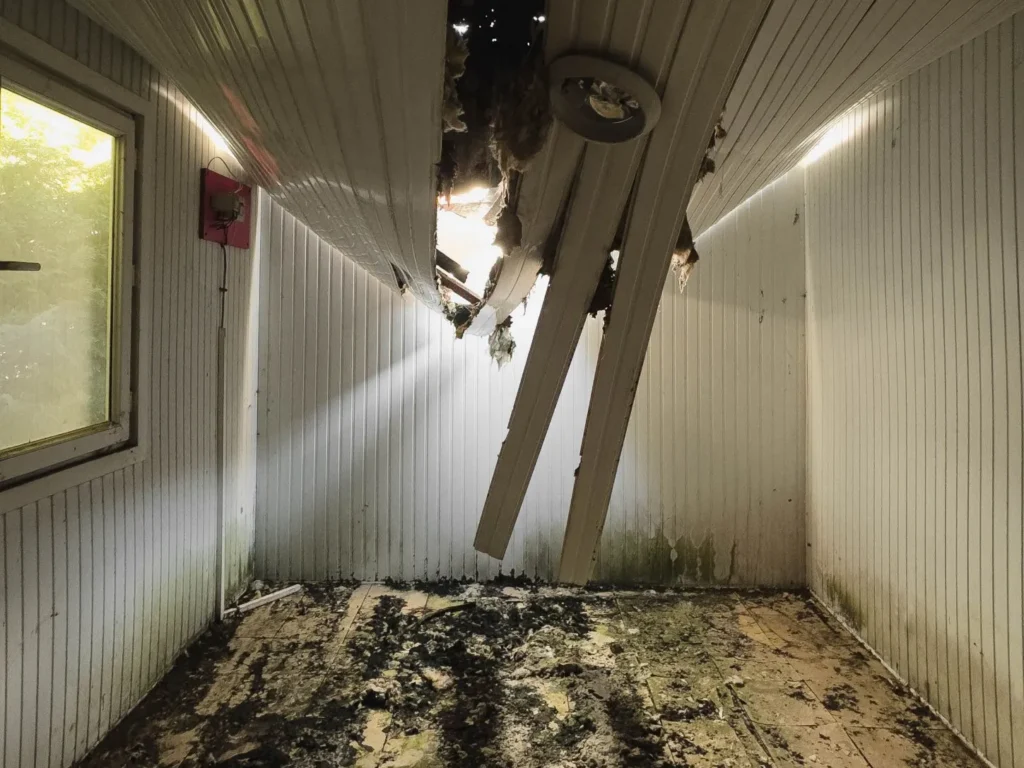 Local endommagé après un sinistre, plafond effondré et débris au sol
