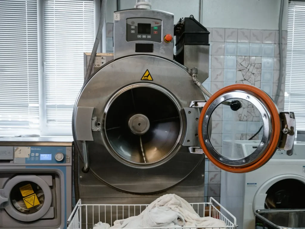 Machine industrielle en inox au tambour ouvert, propre, dans un atelier