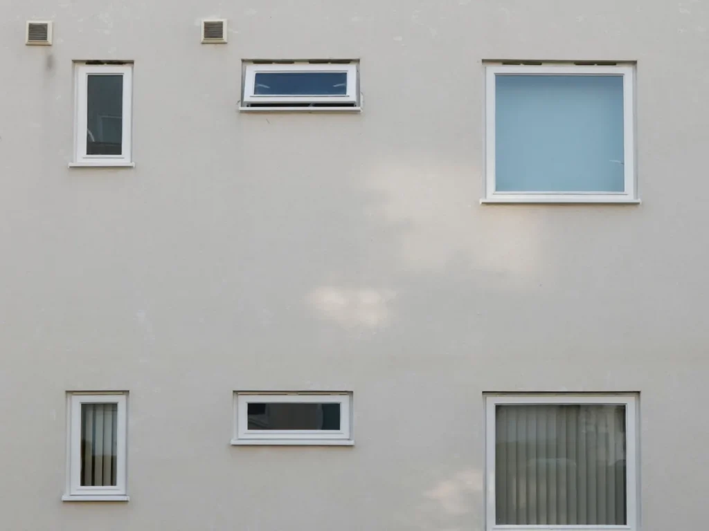 Façade d'immeuble claire et propre avec fenêtres aux cadres blancs